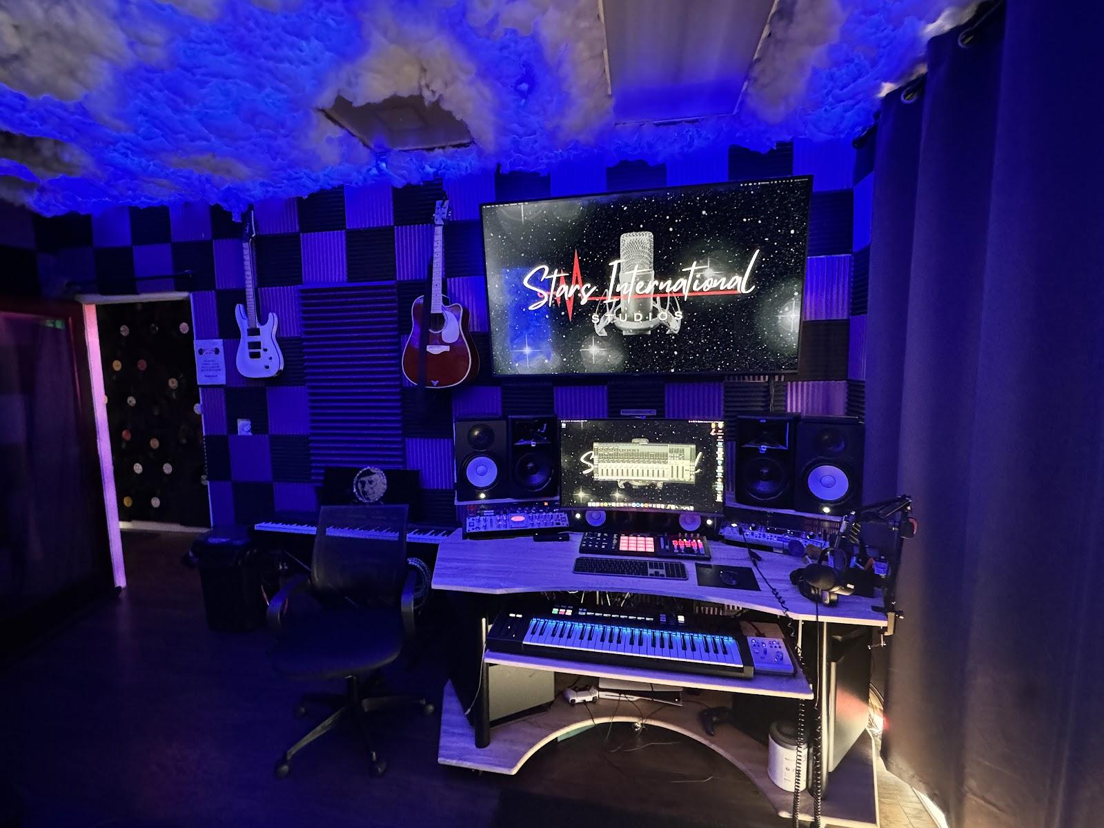 Control room at Stars International, with studio monitors, a keyboard, and guitars on the wall